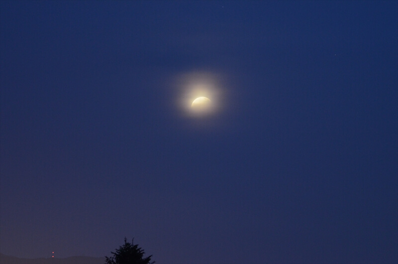 薄明中の欠け始めた月食の写真