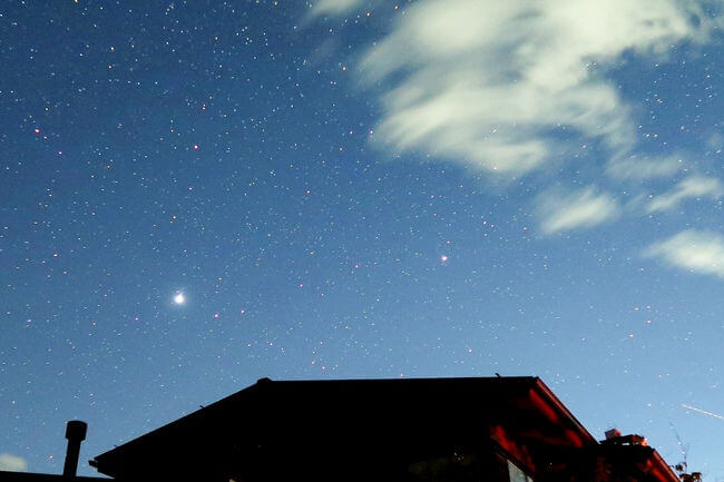 屋根の上に輝く木星や土星の写真