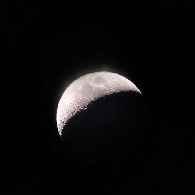 望遠鏡で見た、上弦間近の月の写真