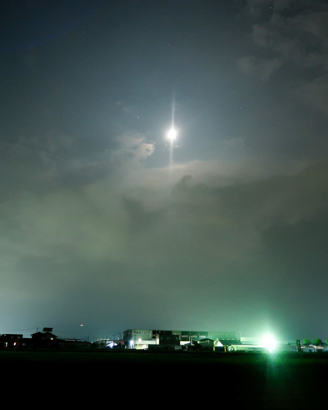 雲の合間から月が出ている